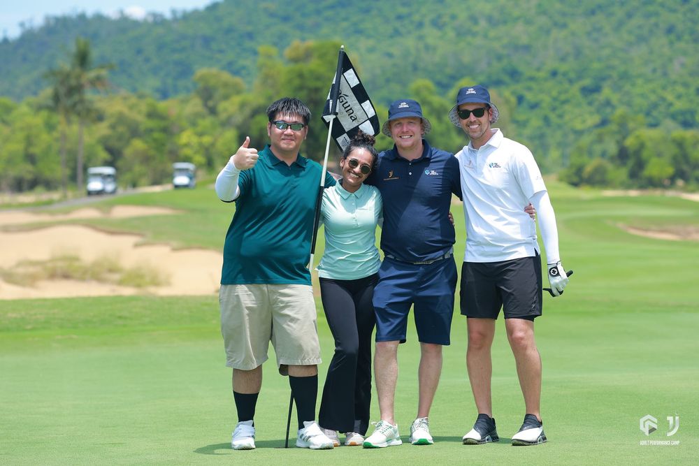 Four players with the pin flag on the final green